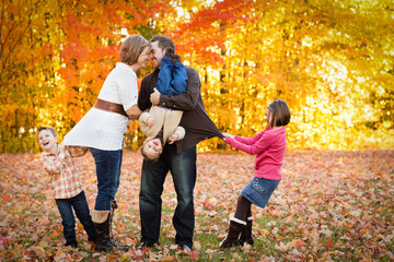 Happy Family Playing Together in Autumn Park