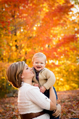 Fototapeta premium Happy Mother Holding Son in Autumn Park