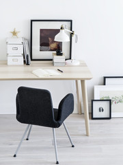 Chair standing near desk and pictures.