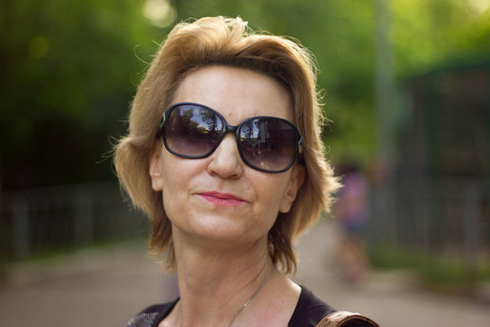 blond middle-aged woman wearing sun glasses