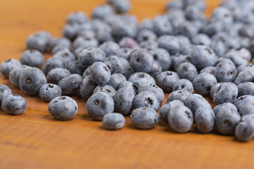 Juicy and fresh blueberries with green mint leaves on a wooden table. Blueberries on wooden background.