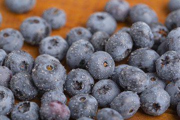 Juicy and fresh blueberries with green mint leaves on a wooden table. Blueberries on wooden background.