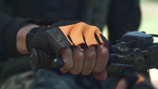 Human hand in sport glove lays at steering brake