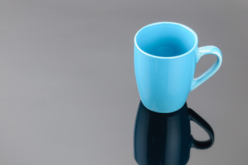 Coffee tea porcelain clay mug on the grey mirror background. Copy space.  .