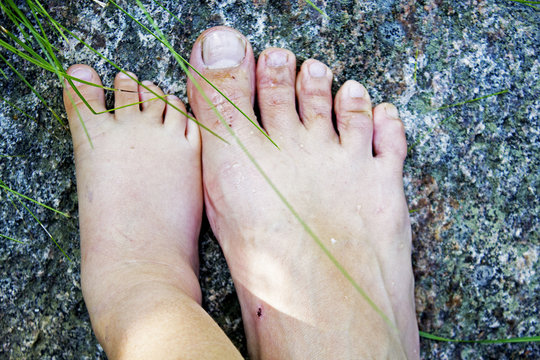 Baby and parent feet standing on stone