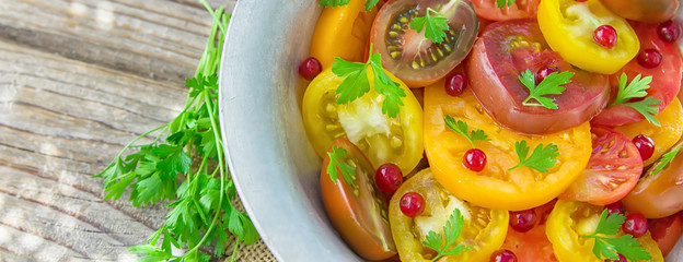 Tasty summer salad of sliced fresh colorful tomatoes, chopped red onion with white currant berries, olive oil,  and parsley. Healthy meal.Banner