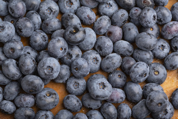 Juicy and fresh blueberries with green mint leaves on a wooden table. Blueberries on wooden background.