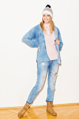 Young woman in pastel denim autumn or winter outfit, studio portrait, full body length. No retouch, no filter.