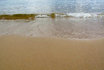 Fototapeta na wymiar Wave of the sea on a sandy beach. Background
