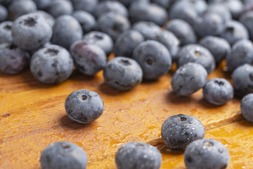 Juicy and fresh blueberries with green mint leaves on a wooden table. Blueberries on wooden background.