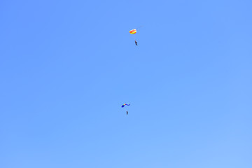 Naklejka na ściany i meble Two paratroopers descend against a blue sky