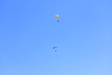 Naklejka na ściany i meble Two paratroopers descend against a blue sky