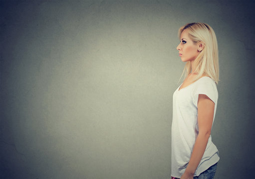 Confident young woman on wall background