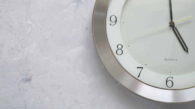 one minute before five on the wall clock with continuously moving time