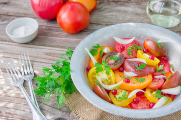 Tasty summer salad of sliced fresh colorful tomatoes, chopped red onion with white currant berries, olive oil,  and parsley. Healthy meal