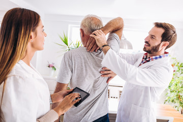 Man having chiropractic arm adjustment. Physiotherapy, sport injury rehabilitation. Senior man exercises in center for chiropractic.