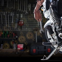 Cropped view of Mechanic using a wrench on a motorcycle