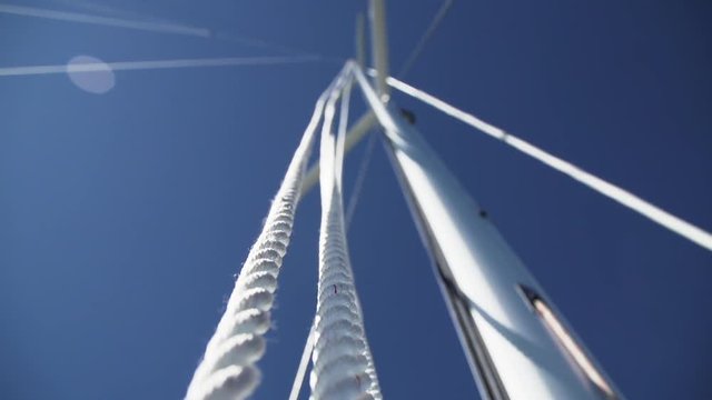Halyard lines running up mast of large sailboat yacht