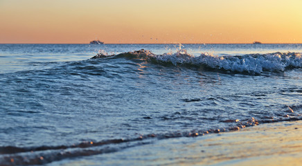 Sea sunset. Surf waves in the light of the setting sun