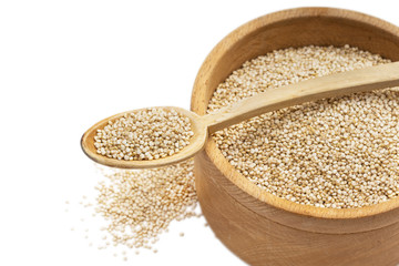 Quionoa seeds in a wooden bowl with a spoon on top and isolated on white background