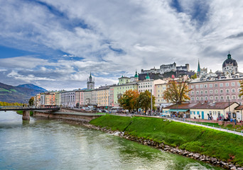 Scenic view of the historic city of Salzburg, Austria, with Salzach river and Hohensalzburg fortress.