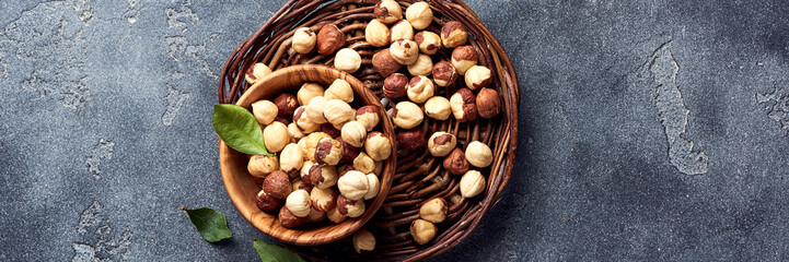Hazelnuts and green leaves on gray background