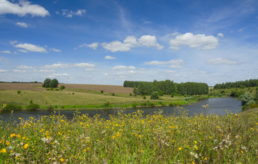 Sunny summer landscape with river,fields,green hills and beautiful clouds in blue sky.Tula region,Russia. 