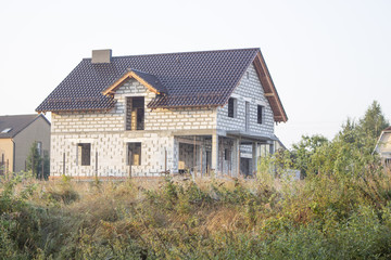 new house under construction stands on top of a hill