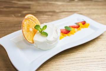 curd dessert with fruits and mint on a white plate