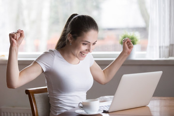 Happy woman working at laptop reading great news online, smiling female excited by email business...