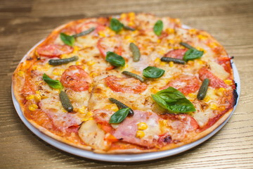 pizza with basil on a white plate