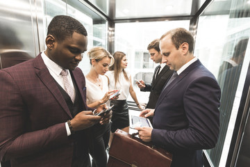 successful and young businessmen in the elevator business center rides to work © xartproduction