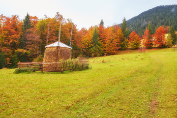 Amazing mountain landscape with fog and a haystack