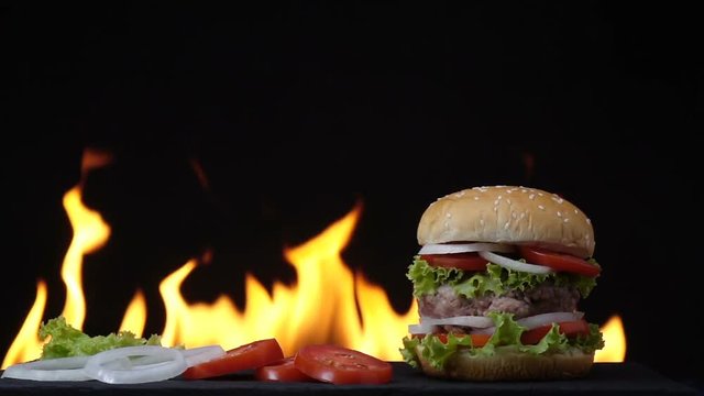Hamburger fast food on fire slow motion background.
