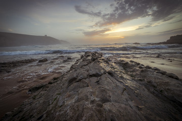 Santander, Sunset in Tagle beach. panoramic view of nice colorful huge cliff and sea on the back. Cantabria. Spain.