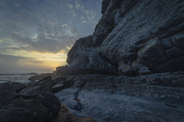 Sunset in Tagle beach. panoramic view of nice colorful huge cliff and sea on the back. Cantabria. Spain.