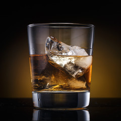 a glass with whiskey and ice on a background