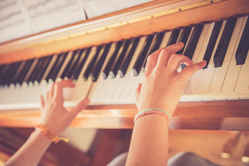 Junges Mädchen spielt leidenschaftlich auf Klavier, Ausschnitt der Hände