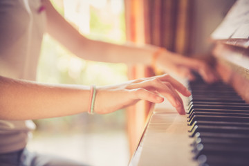 Junges Mädchen spielt leidenschaftlich auf Klavier, Ausschnitt der Hände