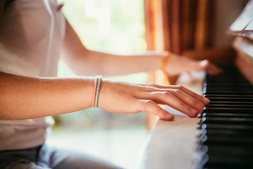 Junges Mädchen spielt leidenschaftlich auf Klavier, Ausschnitt der Hände