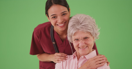 Fototapeta na wymiar Female nurse or caregiver with senior elderly patient smiling on greenscreen