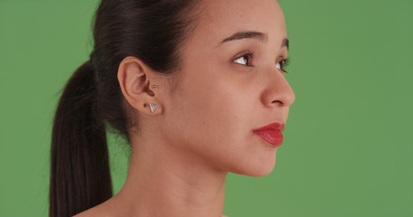 Close-up headshot of a latina girl with red lipstick on green screen