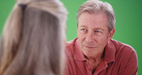 Elderly white man talking with his female companion on greenscreen 