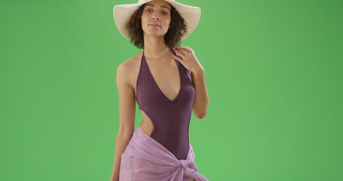 African American woman in sarong and bathing suit and sun hat on green screen