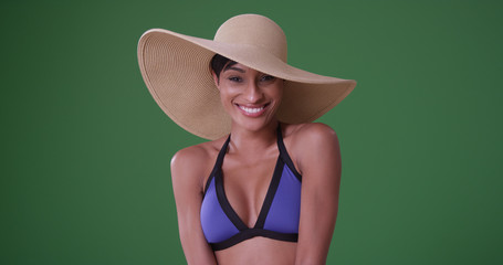 Beautiful black woman in bikini and sunhat enjoying herself on green screen