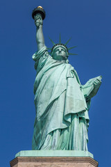 Looking up at The Statue of Liberty against a clear blue sky