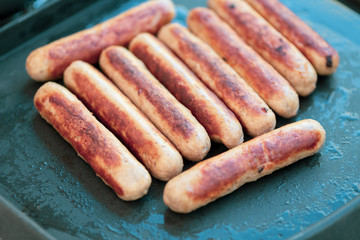 Deutsche Gegrillte kleine weiße Wollwürste Bratwürste ohne Haut auf einer schwarzen Grill Platte