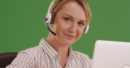 Friendly female receptionist wearing headset representative on green screen