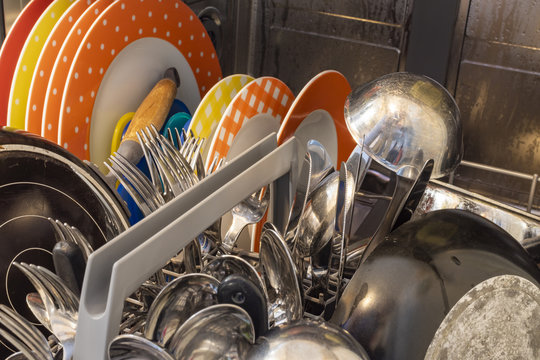 Dishes and cutlery in a dishwasher after the wash.