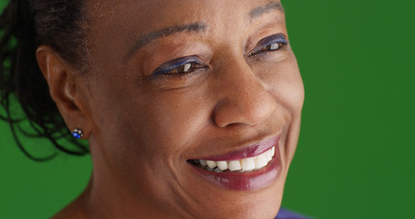 Close-up of smiling mature black woman on green screen